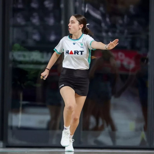 Photo of A-badge umpire Hayley Killer in action, umpiring a game of netball.